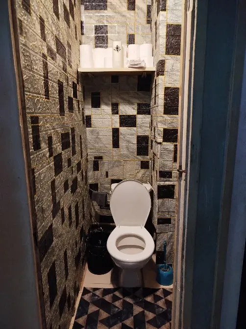 Туалет с кранами и полками для принадлежностей