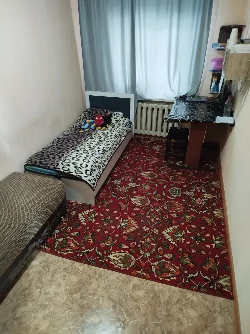 Комната с кроватью, столом и ковром в узор