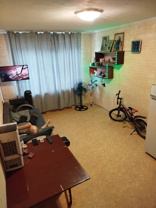 Гостиная с телевизором и велосипедами, светлые шторы