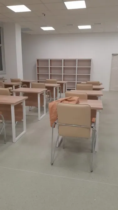 Учебный класс с столами и стульями в светлом интерьере