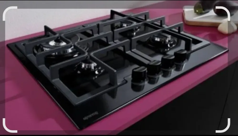 Газовая варочная панель черного цвета с четырьмя конфорками и ручками управления