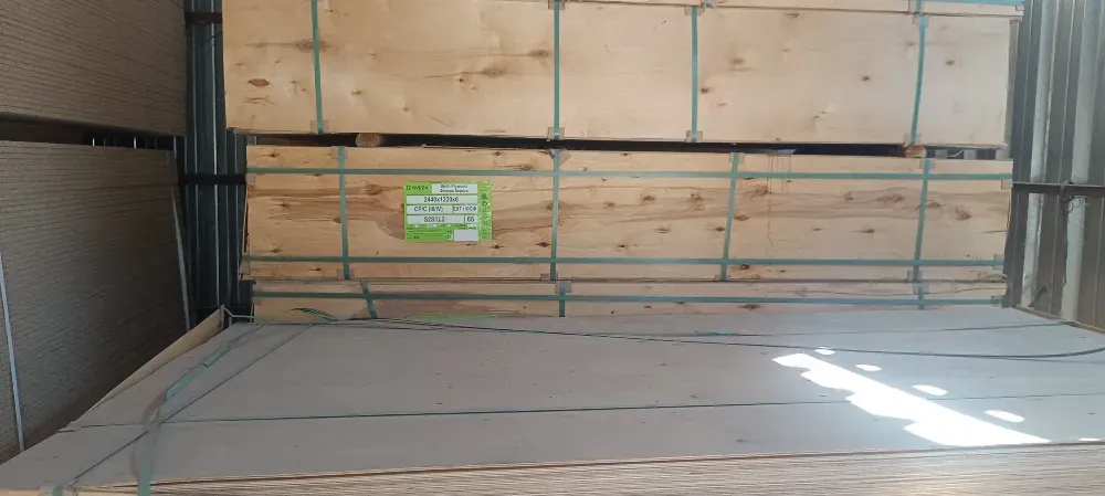 Погруженные в стеллажи листы фанеры, уложенные на паллетах