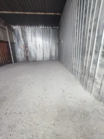 Здание склада с зелёным фургоном на парковке