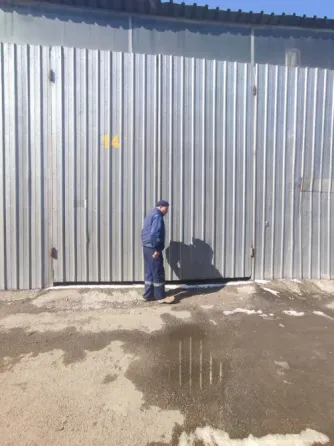 Здание склада с зелёным фургоном на парковке