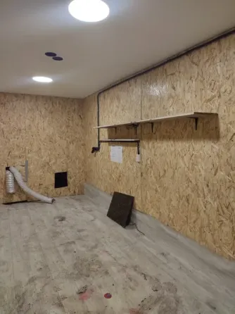 Здание склада с зелёным фургоном на парковке