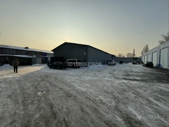 Здание склада с зелёным фургоном на парковке