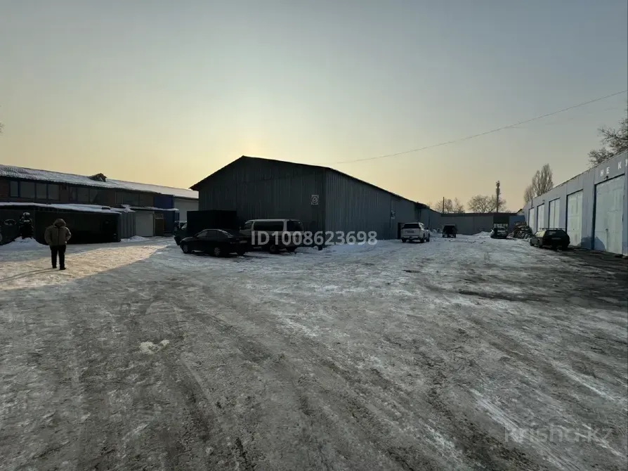 Склад с автомобилями на снегу и закатным солнцем