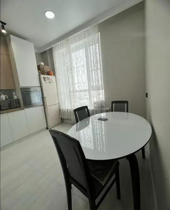 Современная кухня с обеденным столом и светлыми стенами