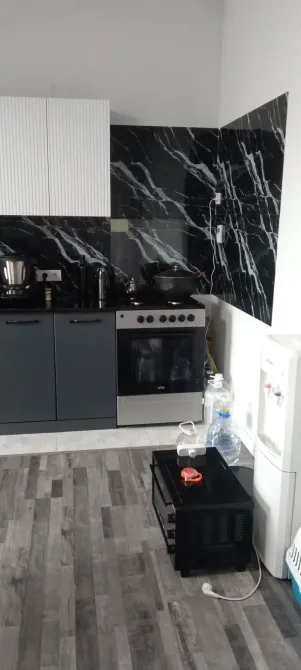 Современная кухня с плитой и черной фартухом