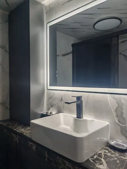 Стильная ванная комната с современным раковиной и зеркалом