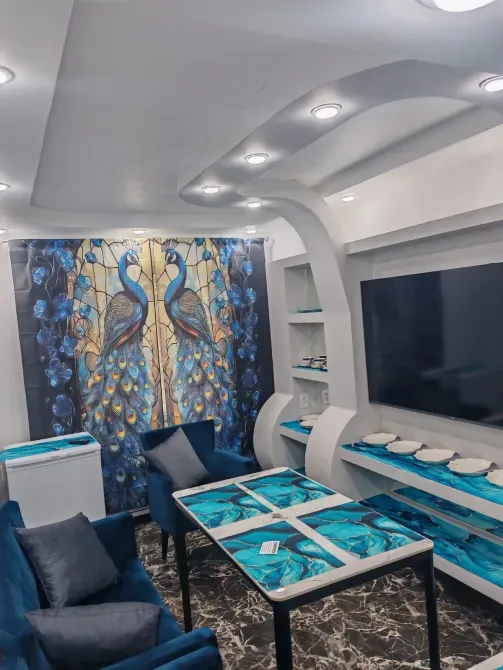 Современный интерьер с витражом павлинов и стильной мебелью