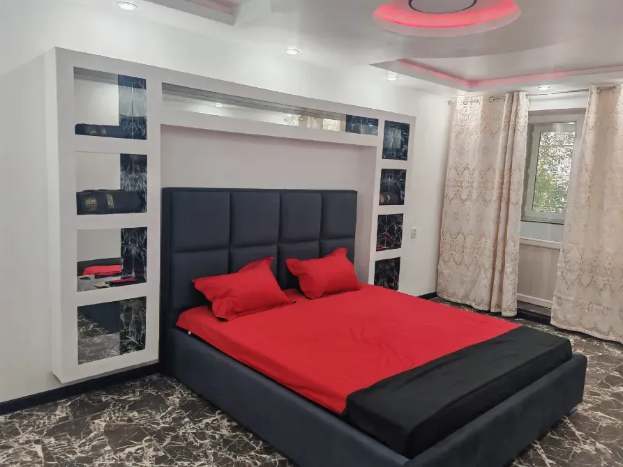 Спальня с яркой красной кроватью и современным интерьером