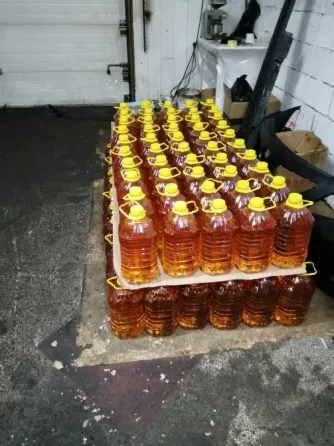 Жарқын сары қақпағы бар бөтелке, оранжевый түсті сұйықтықпен толтырылған, таразыда тұр