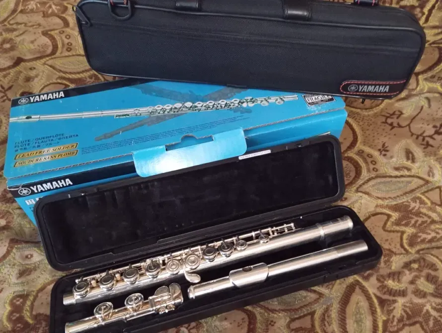 Флейта Yamaha в открытом кейсе с упаковкой на фоне текстиля
