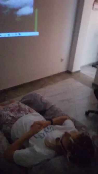 Человек лежит на диване, наблюдая за проекцией на стене