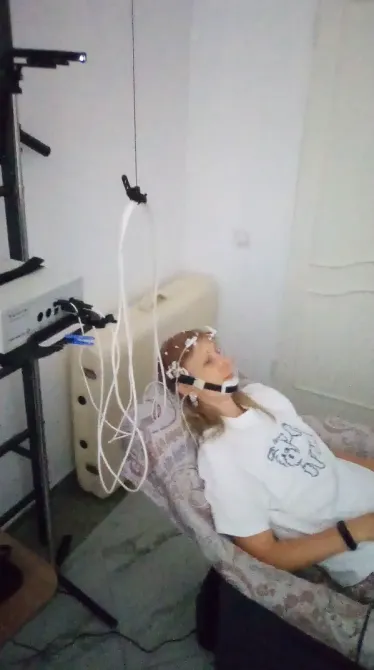 Человек с электроэнцефалографом на голове в лабораторных условиях