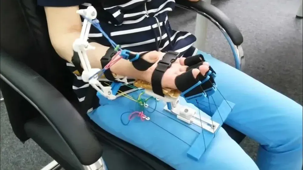 Рука с реабилитационным устройством на столе