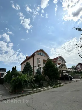 Әдемі архитектурасы мен бағы бар үй, көк аспанның фонында