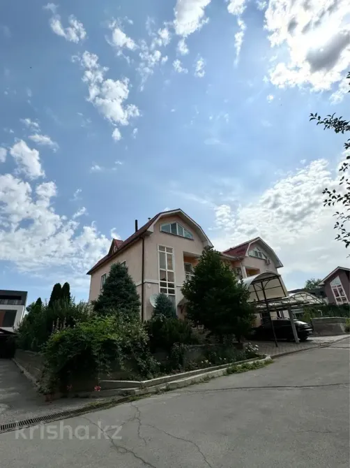 Әдемі архитектурасы мен бағы бар үй, көк аспанның фонында