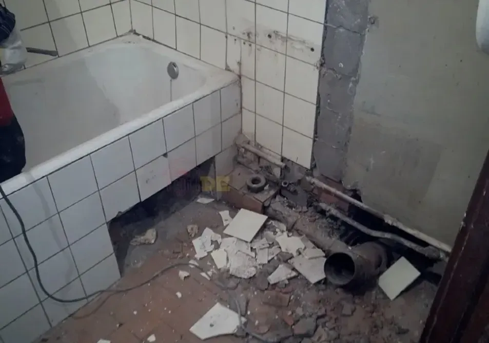 Жөндеуді қажет ететін зақымдалған қабырғалары мен плиткасы бар ванна бөлмелері