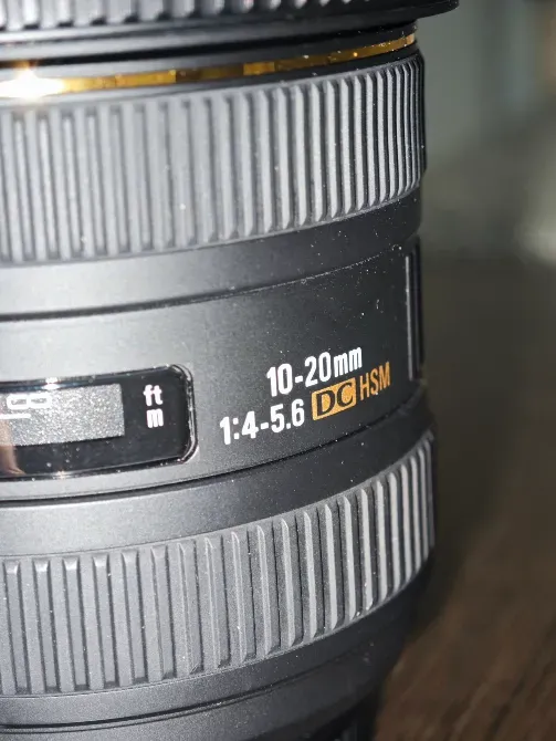 Близкий план объектива Sigma с указанием характеристик на черном фоне
