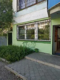 Жасыл өсімдіктермен және кіреберіс есігімен ғимараттың беті