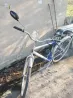 ақ-көк каркасымен велосипед, орнатылған айнамен және жүк сөмкесімен