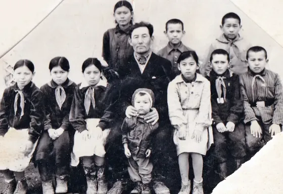 Семейная фотография с мужчиной и группой детей, все в традиционной одежде