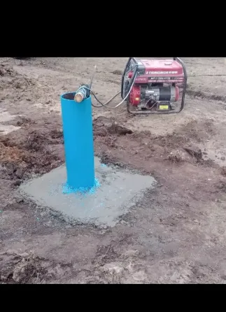 Рука человека на синем ведре с водой на грязной поверхности