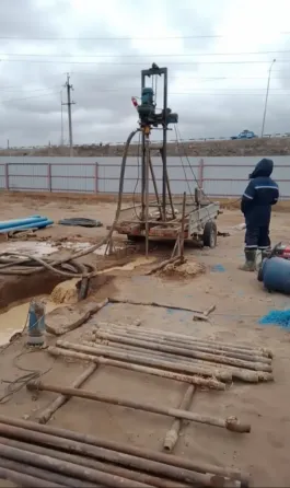 Рука человека на синем ведре с водой на грязной поверхности