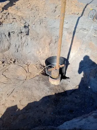 Рука человека на синем ведре с водой на грязной поверхности