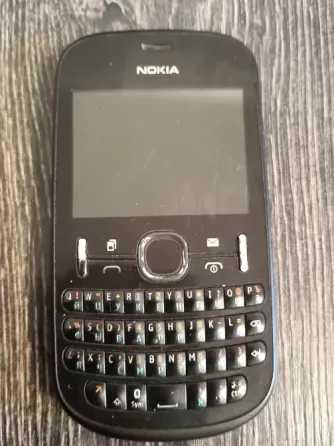 Телефон Nokia Asha 200 в упаковке с зарядным устройством и инструкцией