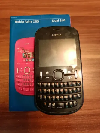 Телефон Nokia Asha 200 в упаковке с зарядным устройством и инструкцией