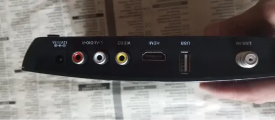 Устройство OTAU TV с логотипом и адресом сайта