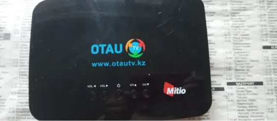 Устройство OTAU TV с логотипом и адресом сайта