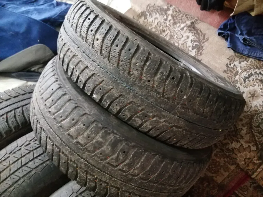 Две изношенные шины, уложенные одна на другую на ковре