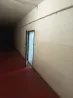 Ұзын дәліз ашық есік пен қызыл еденмен