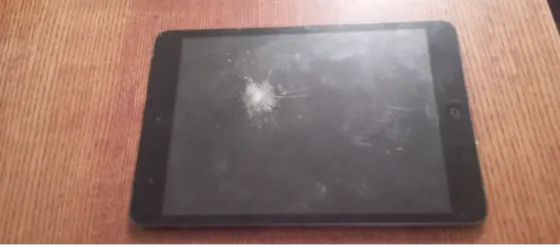 Планшет ASUS и два других устройства, один из которых ярко-желтого цвета с игрушечным улитком, на деревянной поверхности