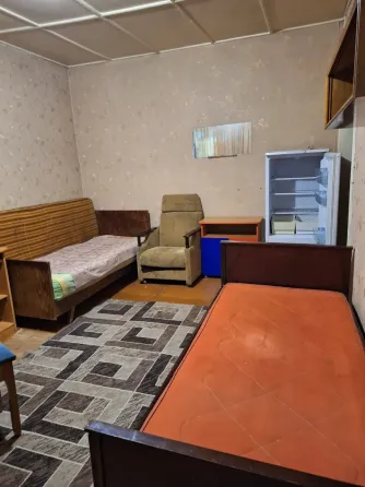Комната с креслом и столом, полы из дерева и ковровое покрытие
