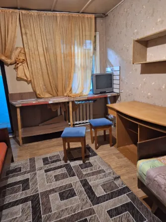 Комната с креслом и столом, полы из дерева и ковровое покрытие