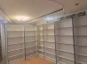 Ақ сөрелер заманауи интерьерде, кітаптарға және декорға арналған бос орын, потолктегі жарықтандыру.