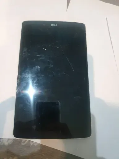Смартфон LG с поврежденным экраном на белом фоне