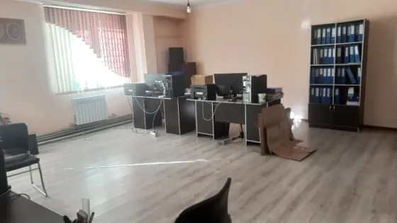 Офисное пространство с несколькими рабочими местами и папками на полках