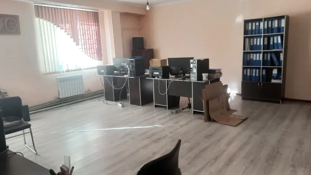 Көптеген жұмыс орындары мен сөрелердегі папкалары бар офис кеңістігі
