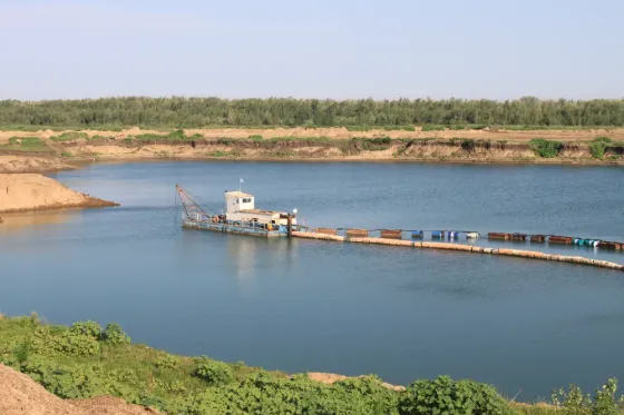 Пейзаж с водой и экскаватором на берегу реки