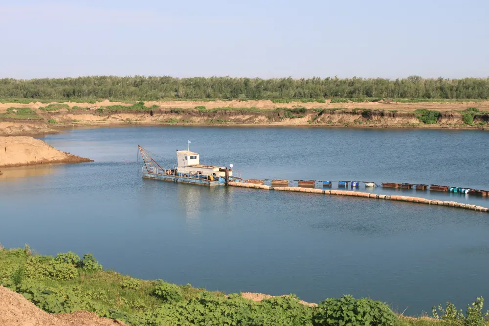 Пейзаж с водой и экскаватором на берегу реки